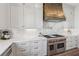Gourmet kitchen with stainless steel range, custom hood, marble backsplash, and ample cabinet space at 204 N Esplanade, Alpharetta, GA 30009