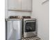 Laundry room with stainless steel washer, dryer, and cabinet storage at 204 N Esplanade, Alpharetta, GA 30009