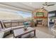 Elegant sunroom has stone fireplace, TV, comfortable sofa and chairs at 204 N Esplanade, Alpharetta, GA 30009