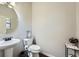 Powder room with a pedestal sink, decorative mirror, dark wood floor, and modern fixtures at 317 Water Oak Ln, Canton, GA 30114