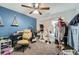 Bedroom with blue wall, an office chair, and clothing racks and accessories at 317 Water Oak Ln, Canton, GA 30114