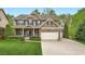 Beautiful two-story home featuring a two car garage, stone accents, and manicured lawn at 317 Water Oak Ln, Canton, GA 30114