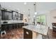 Kitchen featuring dark wood cabinets, stone countertops, and seating at the island at 317 Water Oak Ln, Canton, GA 30114
