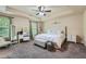 Comfortable main bedroom featuring a tray ceiling, ceiling fan, and plush bedding at 317 Water Oak Ln, Canton, GA 30114