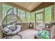 Relaxing sunroom with hanging chair, wicker furniture, and beautiful view of the outdoors at 317 Water Oak Ln, Canton, GA 30114