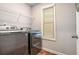 Laundry room features modern washer and dryer units with natural light from the window at 3200 Baylor Cir, Mcdonough, GA 30253