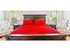 Inviting main bedroom featuring a king-size bed with red bedding and ample natural light from two windows at 3200 Baylor Cir, Mcdonough, GA 30253