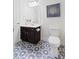 Well-lit bathroom featuring a patterned floor, dark vanity, and artwork above the toilet at 4225 Hopewell Manor Dr, Cumming, GA 30028