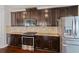 Close up of modern kitchen featuring stainless steel appliances, dark cabinets, and granite countertops at 4225 Hopewell Manor Dr, Cumming, GA 30028
