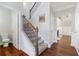 View of the staircase with carpeted steps and rod iron railing leading to the second floor with hardwood floors at 4225 Hopewell Manor Dr, Cumming, GA 30028