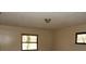 Empty bedroom with dirty walls, two windows, and basic ceiling light at 4269 Mercer Rd, Decatur, GA 30035