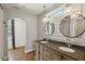 Charming bathroom featuring double sinks, round mirrors, wood paneled walls, modern lighting fixtures, and hardwood floors at 2621 White Oak Dr, Decatur, GA 30032