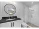 Modern bathroom with round mirror, vanity, and tiled shower with glass door at 96 The Prado Ne, Atlanta, GA 30309
