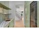 Butler pantry with marble countertop, brass sink, green cabinetry and adjacent wine refrigerator at 96 The Prado Ne, Atlanta, GA 30309
