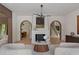 Elegant living room with fireplace, arched doorways, modern lighting, and light hardwood flooring at 96 The Prado Ne, Atlanta, GA 30309