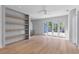 Open living room featuring hardwood floors, built-in shelving, and patio doors to an outdoor area at 96 The Prado Ne, Atlanta, GA 30309