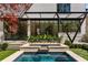 Gorgeous pool with attached spa and rock waterfall feature, alongside a covered patio and meticulous landscaping for stylish outdoor living at 96 The Prado Ne, Atlanta, GA 30309
