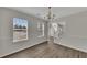 Well-lit dining room with chandelier, hardwood floors, neutral walls, and large windows at 3635 Spring Mesa Dr, Snellville, GA 30039