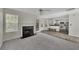 Open-concept living room with fireplace, access to the kitchen, and lots of natural light at 3635 Spring Mesa Dr, Snellville, GA 30039