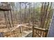 View of the elevated back porch looking out to a wooded lot at 6490 Lake Esther Dr, Fairburn, GA 30213
