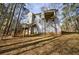 Back of the house featuring an elevated deck and stairway to the large wooded backyard at 6490 Lake Esther Dr, Fairburn, GA 30213