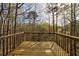 View of the wooded backyard from the home's wooden deck, perfect for relaxing outdoors at 6490 Lake Esther Dr, Fairburn, GA 30213