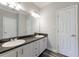 Bathroom with double sink vanity, granite countertop, and stylish wood-look flooring at 6490 Lake Esther Dr, Fairburn, GA 30213