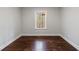 Bedroom with a window showing a wooded view and shiny hardwood floors at 6490 Lake Esther Dr, Fairburn, GA 30213