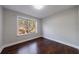 Bedroom with a large window showing a wooded view and shiny hardwood floors at 6490 Lake Esther Dr, Fairburn, GA 30213