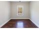 A minimalistic bedroom with wood floors features a window that illuminates the room at 6490 Lake Esther Dr, Fairburn, GA 30213