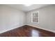 Bedroom with a window showing a wooded view and shiny hardwood floors at 6490 Lake Esther Dr, Fairburn, GA 30213