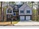 Charming two-story home with blue shutters, stone accents, and a two-car garage at 6490 Lake Esther Dr, Fairburn, GA 30213