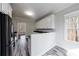 Bright kitchen with white cabinetry, wood-look floors, stainless steel appliances, and a natural light window at 6490 Lake Esther Dr, Fairburn, GA 30213