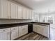 Bright kitchen with white cabinetry, wood-look floors, black appliances, and a breakfast nook at 6490 Lake Esther Dr, Fairburn, GA 30213