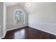 Bright living room with dark wood floors, arched window, and neutral wall paint at 6490 Lake Esther Dr, Fairburn, GA 30213