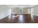 Living room featuring gleaming hardwood floors and natural light from large windows at 6490 Lake Esther Dr, Fairburn, GA 30213
