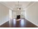 Spacious living room featuring hardwood floors, a fireplace, and a tray ceiling with ceiling fan at 6490 Lake Esther Dr, Fairburn, GA 30213