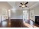 Bright and airy living room with hardwood floors, fireplace, ceiling fan, and multiple windows at 6490 Lake Esther Dr, Fairburn, GA 30213