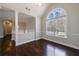 Bright living room with dark wood floors, arched window, and neutral wall paint at 6490 Lake Esther Dr, Fairburn, GA 30213