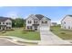 Charming two-story home with a gray brick facade, lush lawn, and a two-car garage at 989 Blue Juniper Cir, Loganville, GA 30052