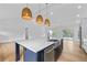 Modern kitchen with a large island, white cabinets, stainless steel appliances and wicker pendant lights at 1194 Clearview Ne Dr, Brookhaven, GA 30319