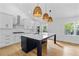 Modern kitchen with a large island, white cabinets, stainless steel appliances and wicker pendant lights at 1194 Clearview Ne Dr, Brookhaven, GA 30319