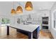 Modern kitchen with a large island, white cabinets, stainless steel appliances and wicker pendant lights at 1194 Clearview Ne Dr, Brookhaven, GA 30319