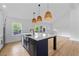 Modern kitchen with a large island, white cabinets, stainless steel appliances and wicker pendant lights at 1194 Clearview Ne Dr, Brookhaven, GA 30319