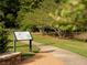 Scenic pathway through a park featuring informational signage and well-manicured landscaping at 7110 Summit Pl, Alpharetta, GA 30009
