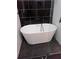 Modern bathroom featuring a sleek freestanding tub, black tile accents, and contrasting flooring at 2565 Cloud Ln, Decatur, GA 30034