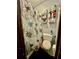 Tight bathroom with a floral shower curtain and shelf storage at 6917 Laurelwood Dr, Douglasville, GA 30135