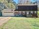A home with a brick facade, a two-car garage, and a small deck at 6917 Laurelwood Dr, Douglasville, GA 30135