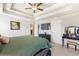 Main bedroom with a trey ceiling, ceiling fan, carpet, and dark furniture at 1661 Flagstone Ln, Conyers, GA 30012