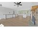 Open-concept living room featuring a stone fireplace, wood floors, and a ceiling fan for a bright and welcoming space at 81 Bridgemill Dr, Douglasville, GA 30134